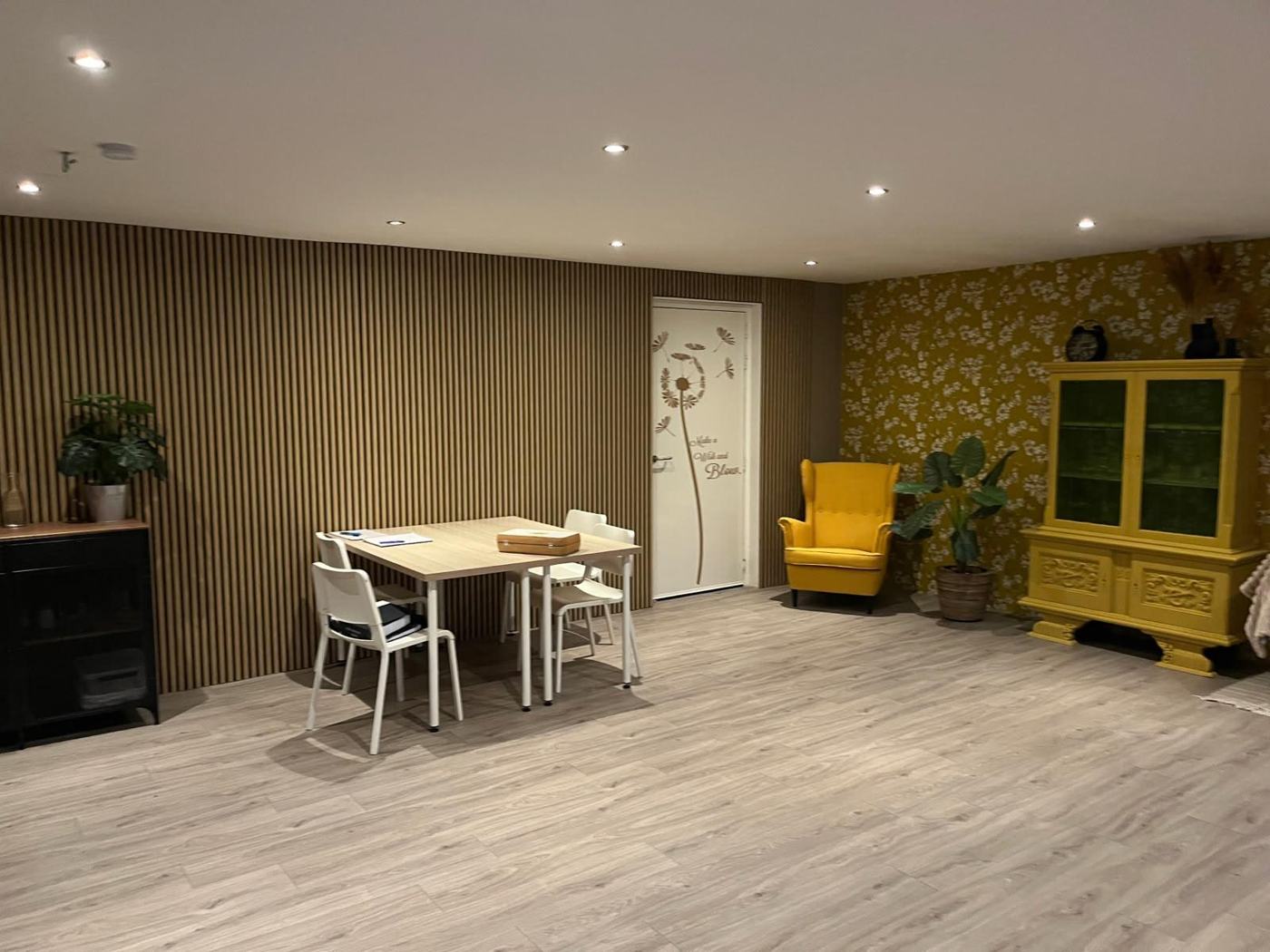 De praktijkruimte van nuJIJ met een tafel, gele stoel en kast